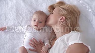 生命中最美好的时刻，爱的年轻母亲拥抱并亲吻一个刚出生的女儿的毯子和镜头